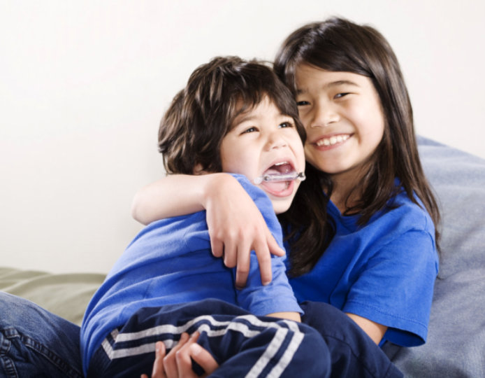 elder sister hugging her brother